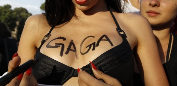 Manifestante da parada gay italiana escreve o nome de Lady Gaga nos seios enquanto espera a chegada da cantora (11/6/2011) - Stefano Rellandini/Reuters